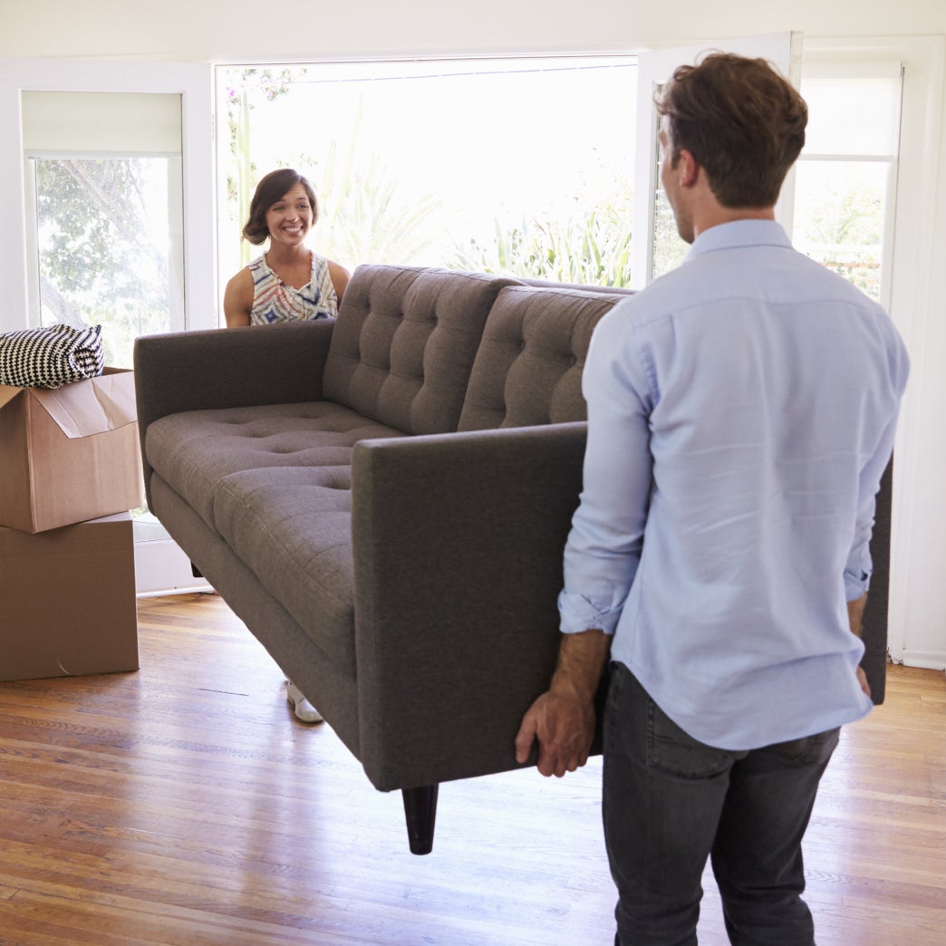 Two people moving a couch